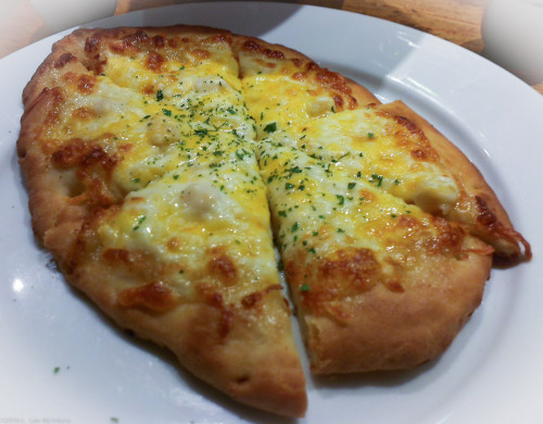 Flatbread topped with melted cheese and scallop-mayo mixture