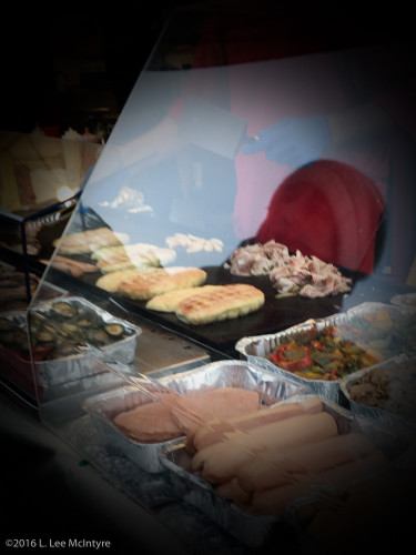 Porchetta (roast pork) and roll being heated on the grill (behind the hotdogs)