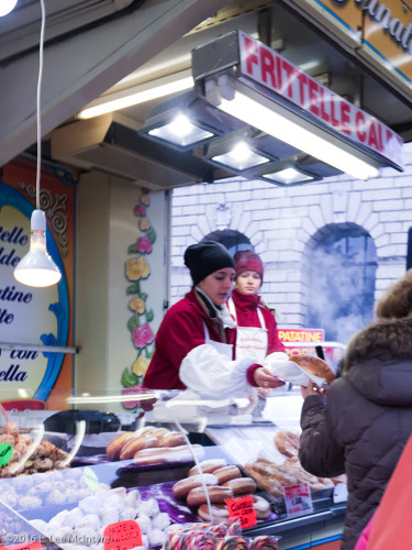 A worker handing over a <em>fritella</em> to a customer